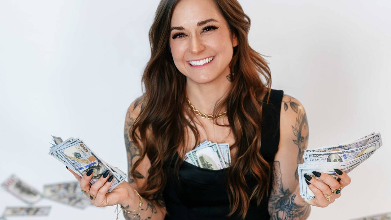 Money coach Chloe Daniels holding cash during a financial planning photoshoot.