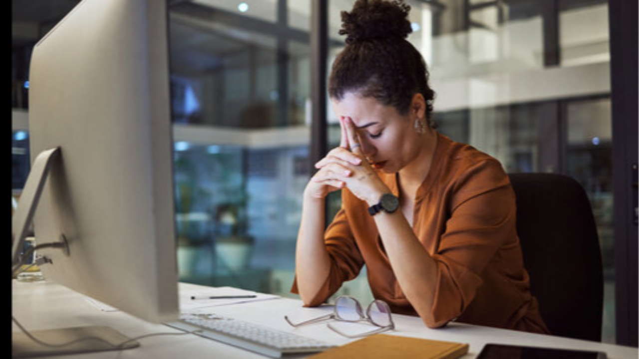 Overwhelmed business owner feeling stuck and stressed while working at her desk