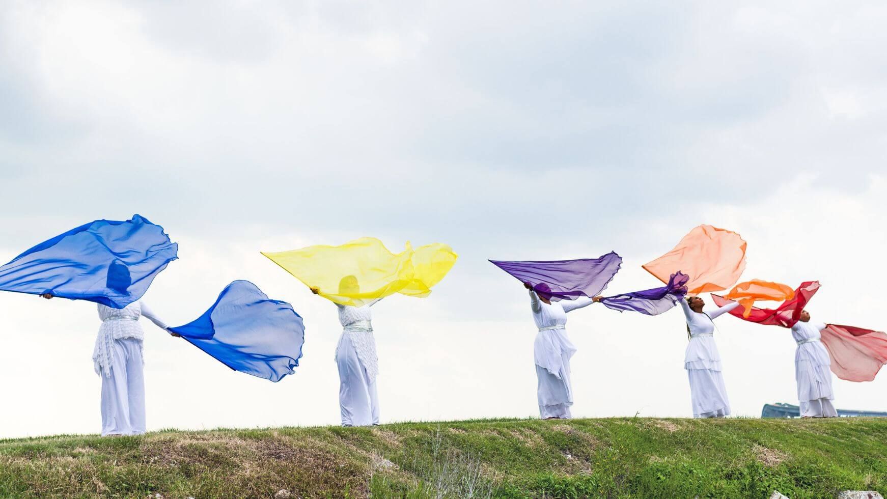 Handmade worship flags in vibrant colors used for expressive praise and worship outdoors.