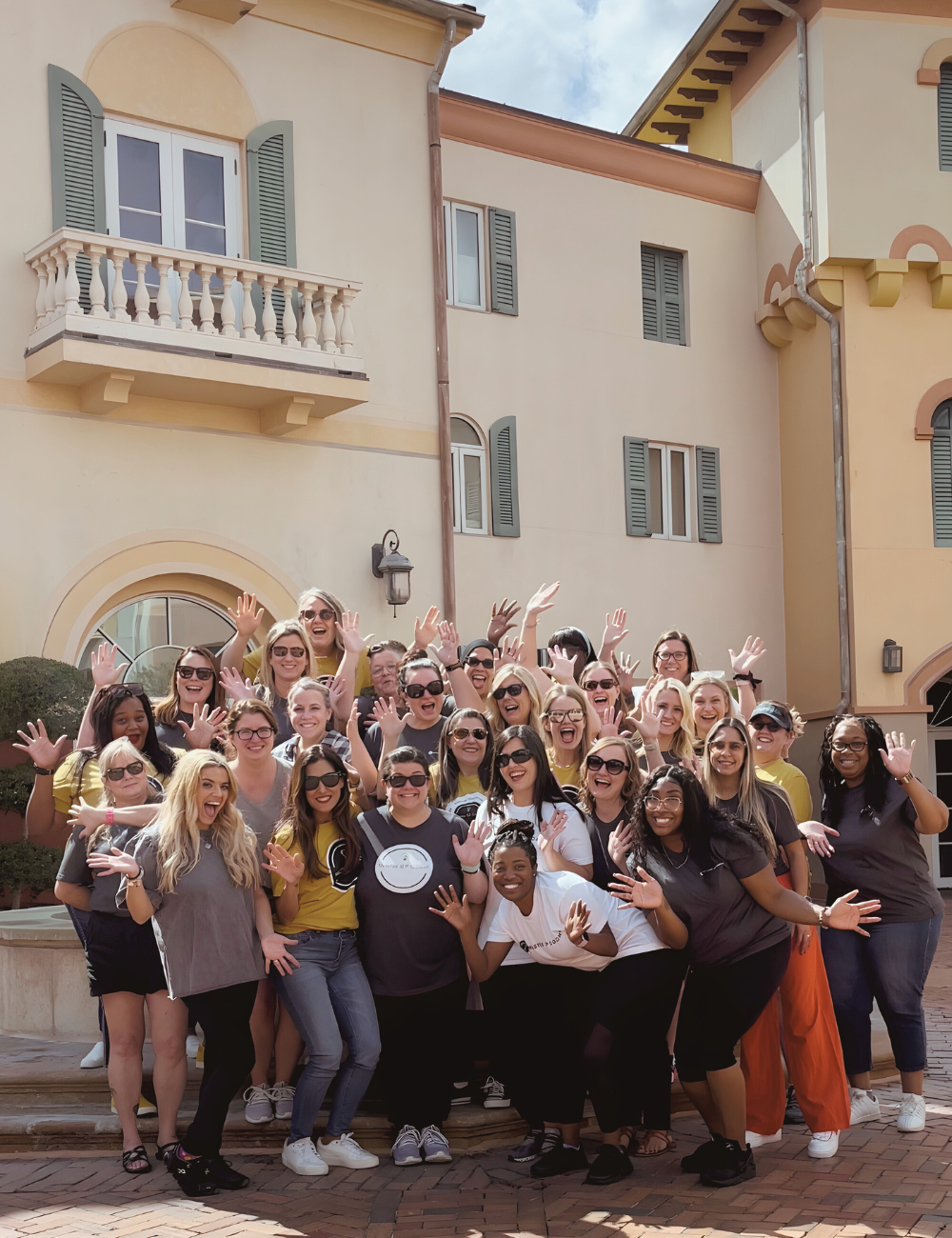 Master IEP Coaches gathered outside at a retreat, waving