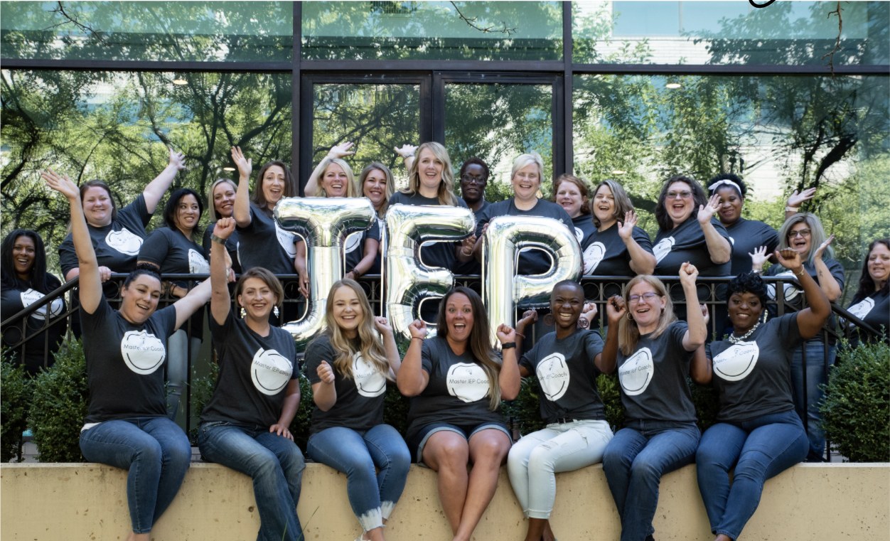 Master IEP Coaches cheering behind IEP balloon letters