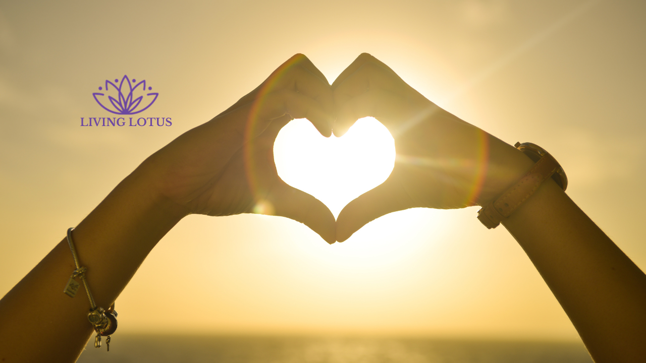 Two hands up to form a heart with the sun behind