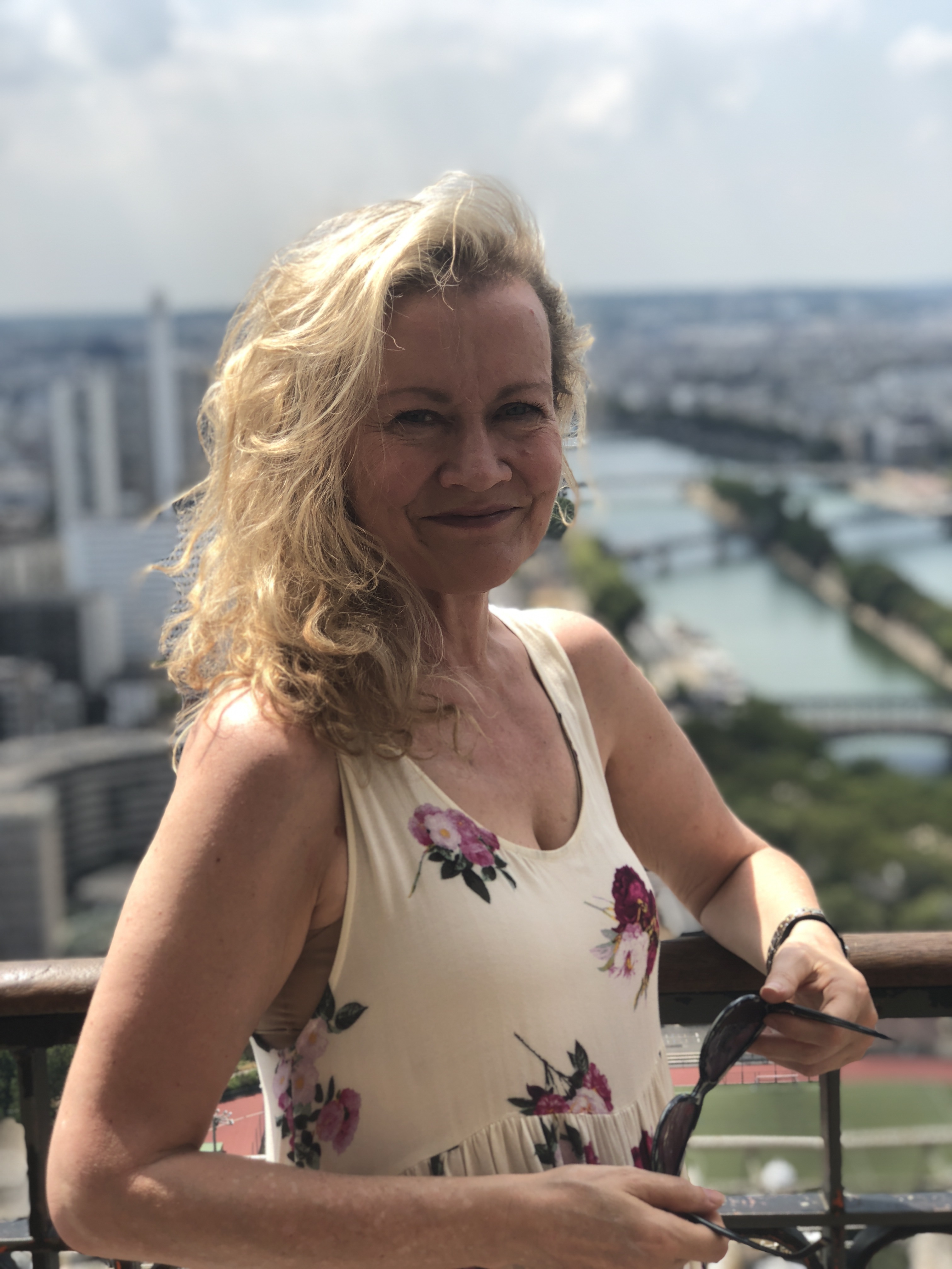 Perry Janssen, psychotherapist, smiling high above Paris and the Seine