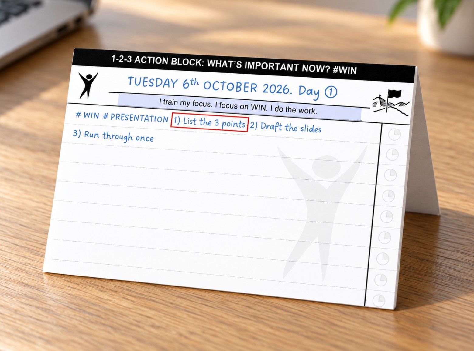 The folded 1-2-3 Action Block card standing on a wooden desk, with the first action boxed
