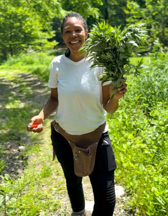 Selima Harleston Lust holding mugwort, an herb central to Iwilla Remedy's herbal practice