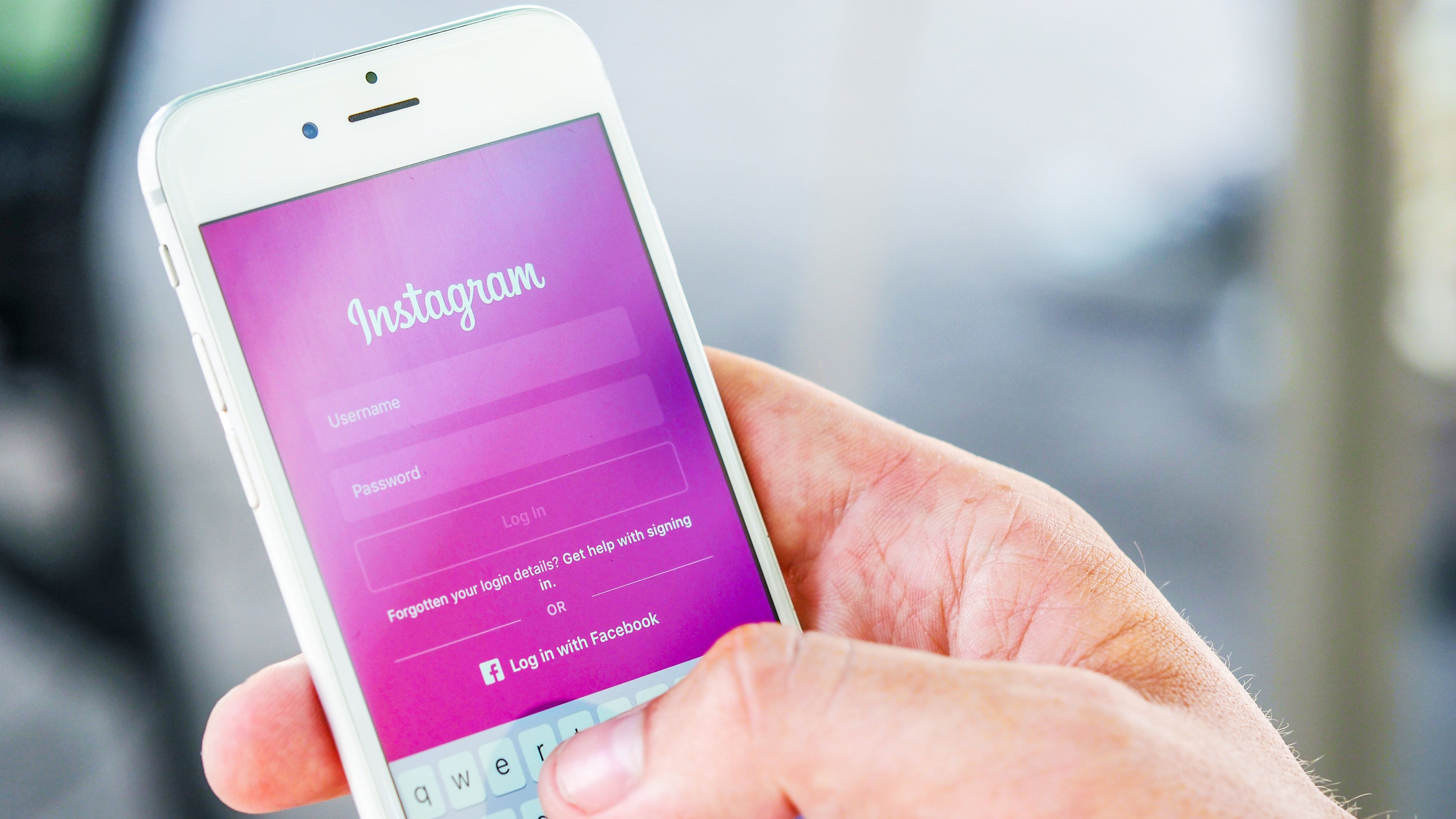 Image of hand holding cellphone logging into Instagram