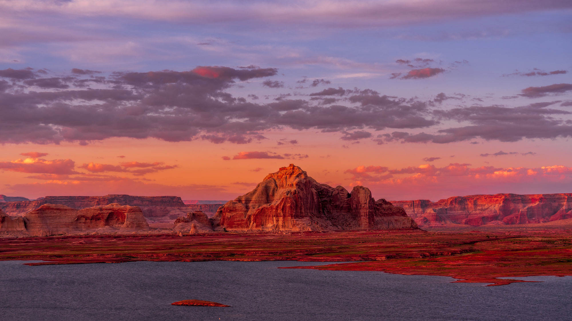 Lake Powell at sunset near Page, Arizona with red rock buttes and pink sky