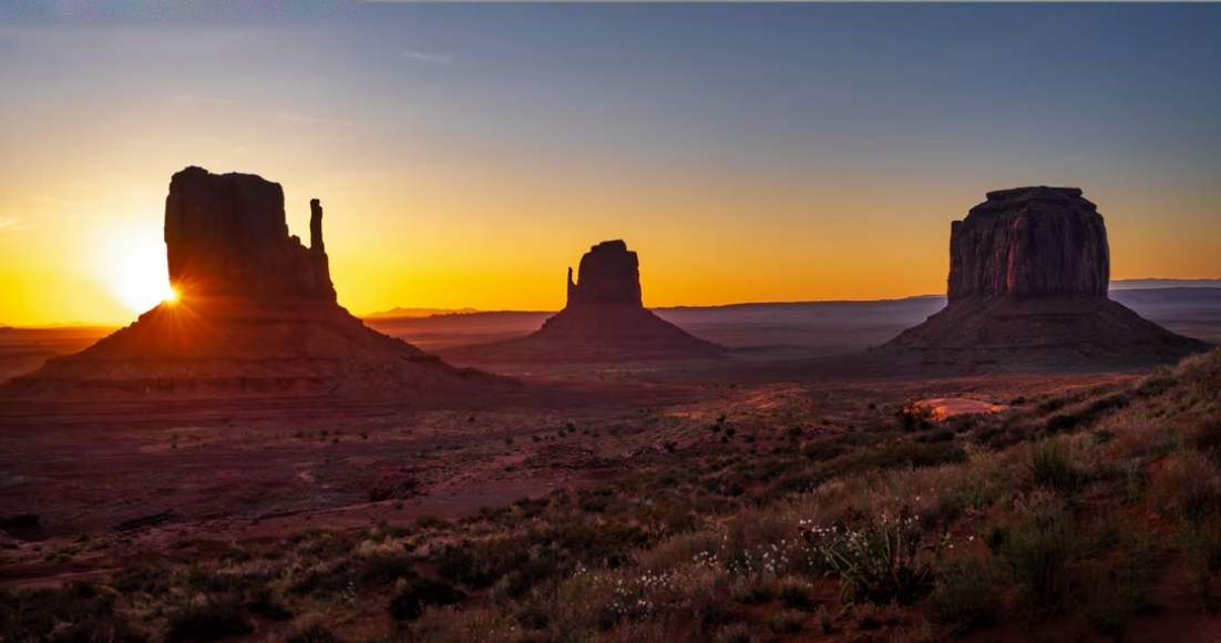 Monument Valley at sunrise with the horizon placed near the middle of the frame