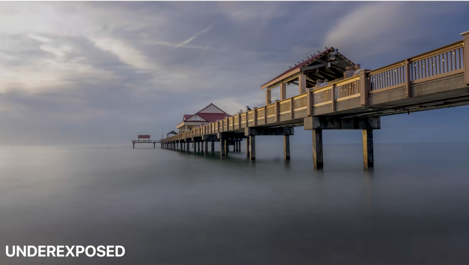 An underexposed version of the pier sunset photo protecting the highlights in the sky