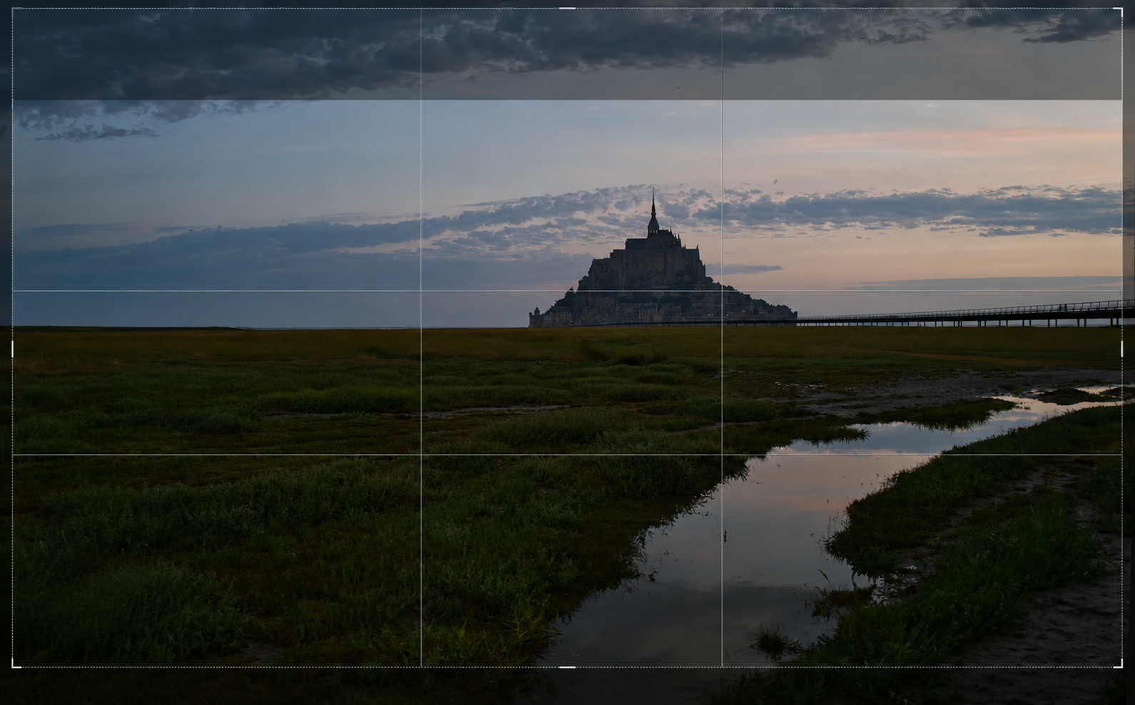 Crop AI adjusting the composition of the Mont Saint-Michel photo to a 16:9 ratio with a rule-of-thirds grid in Luminar Neo