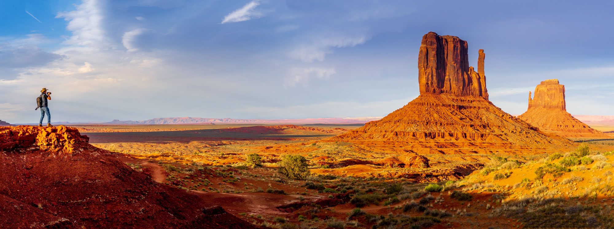 Photographer overlooking the Mittens in Monument Valley, panorama