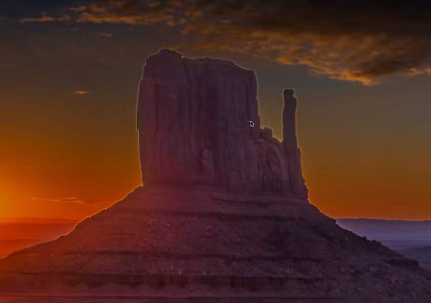 A crisp Monument Valley rock silhouette against a sunset sky, exactly the kind of high-contrast edge that turns into a glowing halo