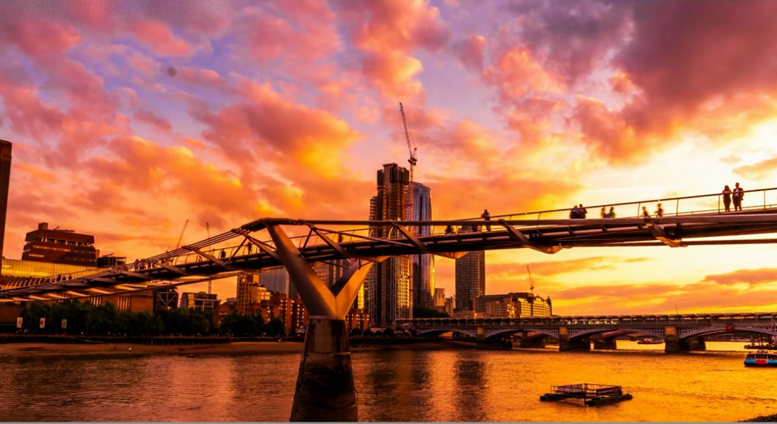 An over-edited photo of the Millennium Bridge at sunset in London, oversaturated with unnatural halos