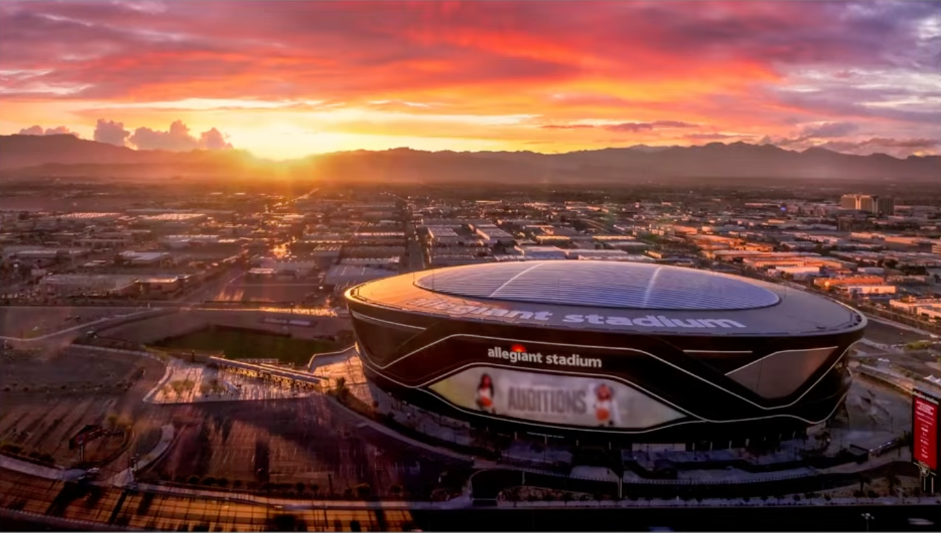 The same Allegiant Stadium shot with a dramatic AI-generated pink and orange sunset sky