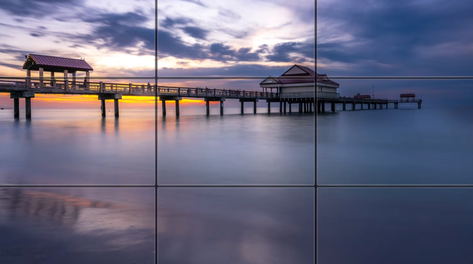 A rule-of-thirds grid overlaid on the pier sunset composition