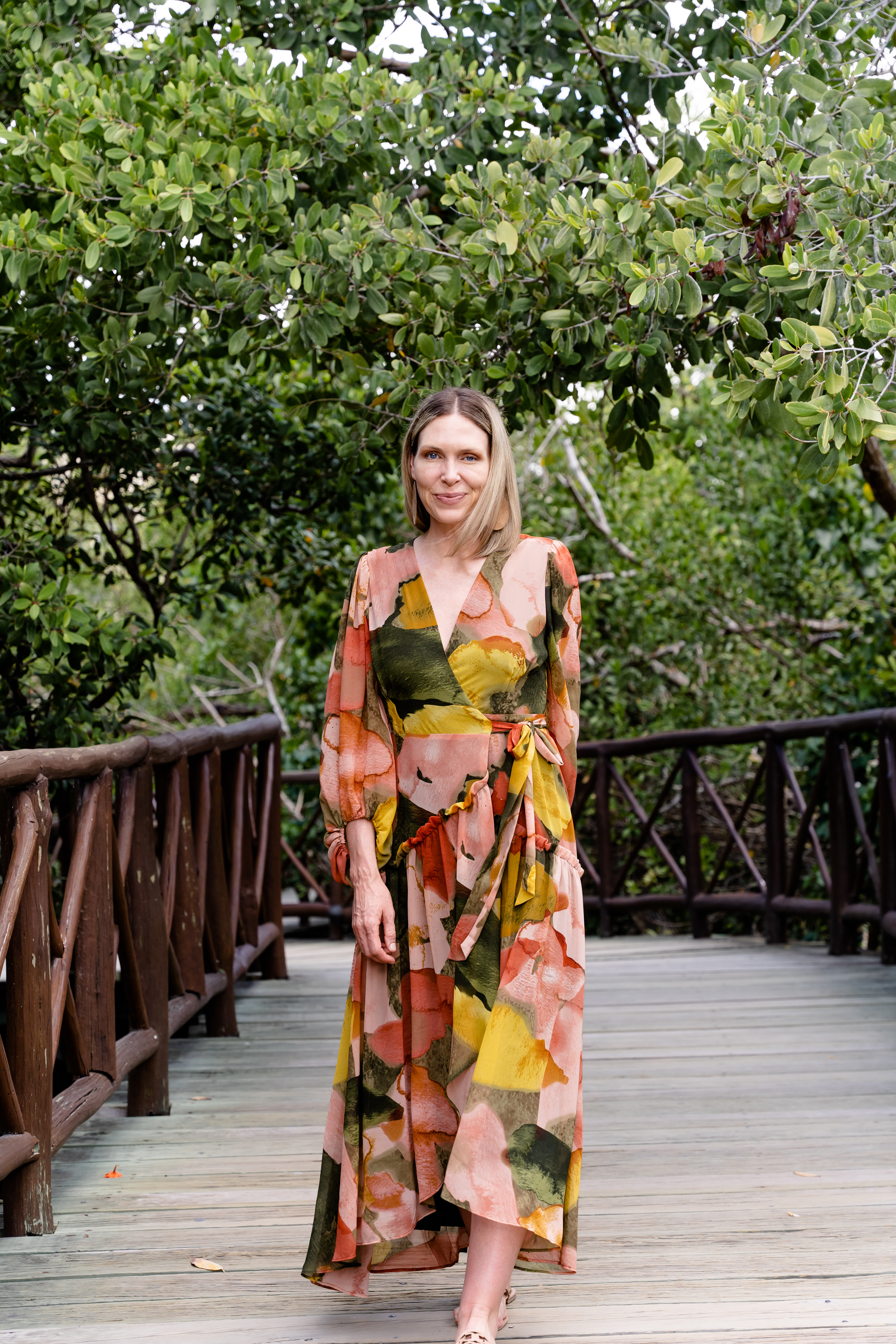 Alana Chernecki in a colorful floral dress in a natural setting