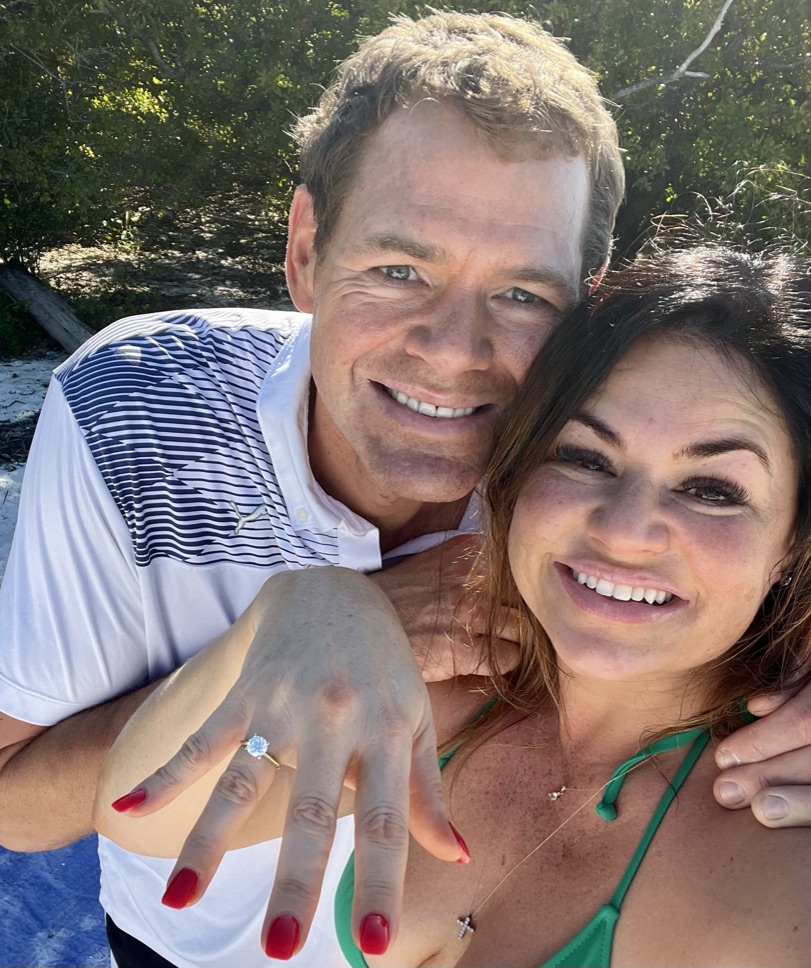 Melissa and Iain smiling together after their engagement, with her ring visible