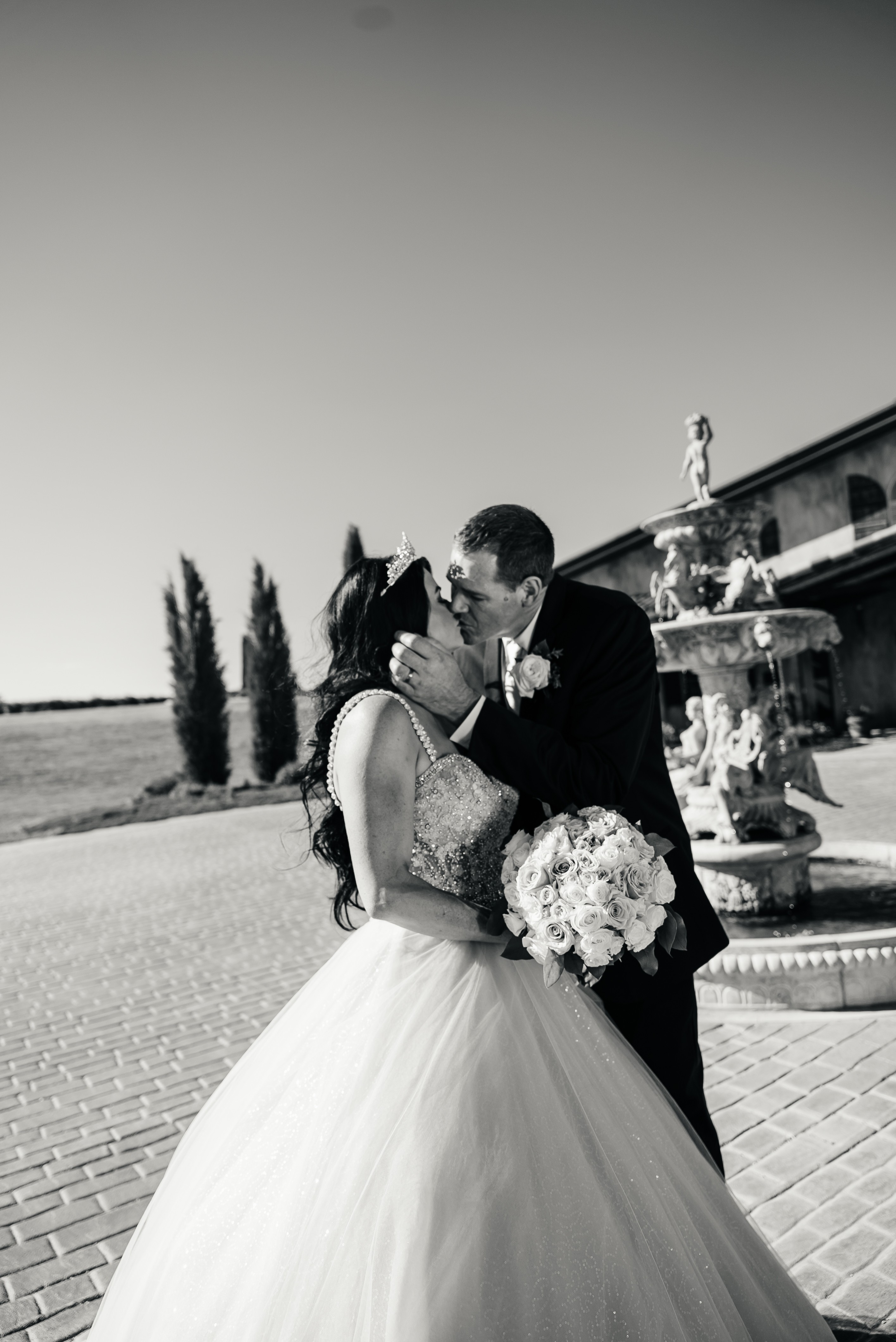 Melissa and Iain sharing a kiss beside the fountain on their wedding day