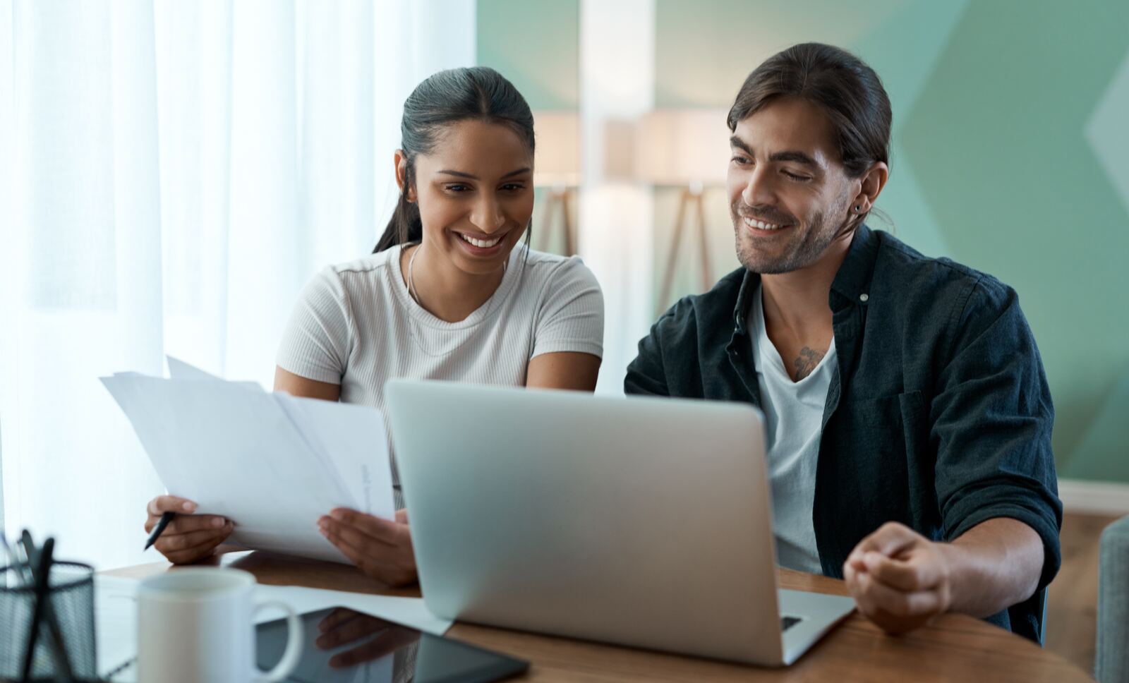 Couple reviewing documents together on a laptop at home while preparing a Canadian spousal sponsorship application