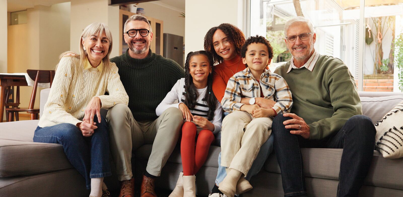Grandparents, parents and children posing together on a sofa, illustrating Canadian citizenship by descent across generations