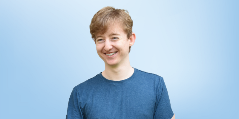 Raymond Gordon, Store Manager for the Healing Touch Program, smiling against a light blue background.
