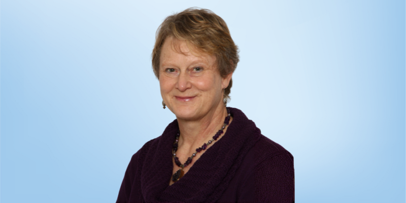 Jeannette Nienaber, instructor manager at the Healing Touch Program, smiling against a light blue background.