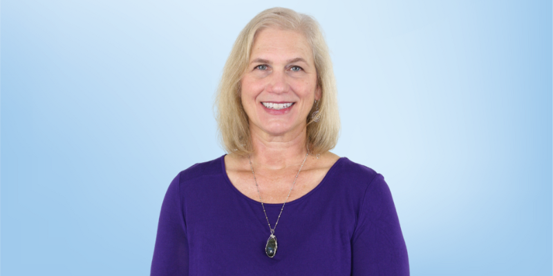 Sue Walker, education director and leadership team member at the Healing Touch Program, smiling against a light blue background.
