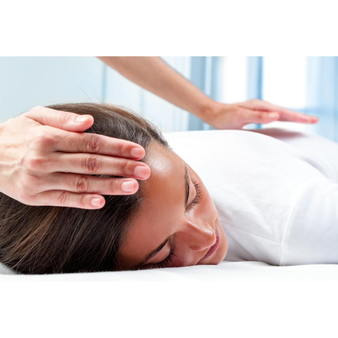 Client receiving a Healing Touch session — relaxed, fully clothed, hands lightly placed to balance energy field for stress relief and healing.