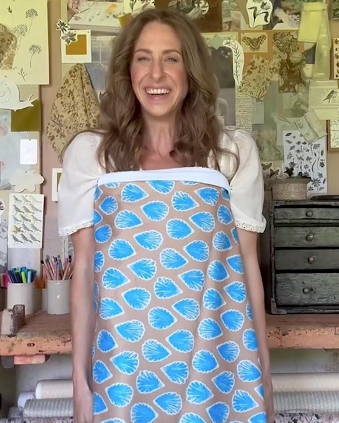Bonnie holding a tea towel printed with her pattern