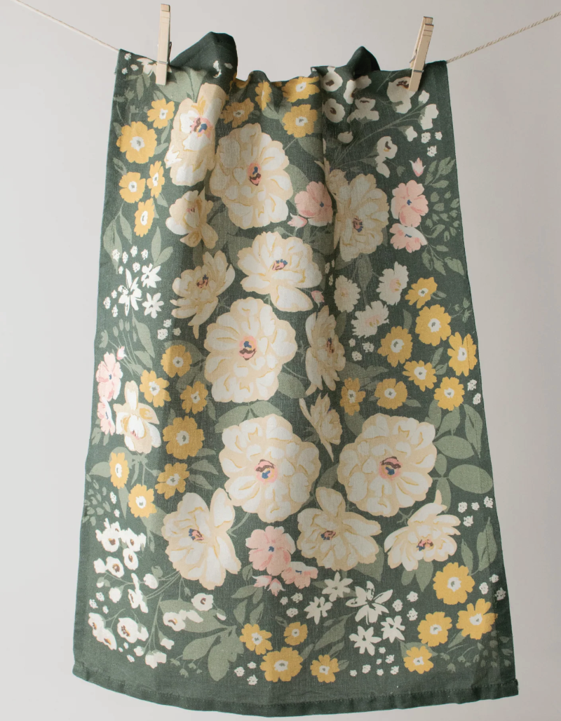 A tea towel printed with Bonnie’s floral pattern, hanging on a line
