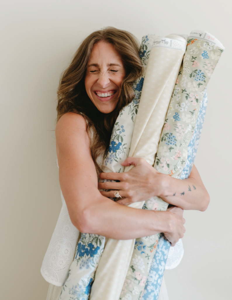 Bonnie hugging bolts of fabric printed with her patterns