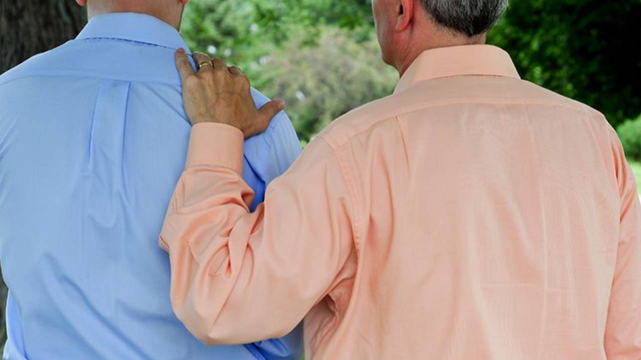 Man with hand on another's back