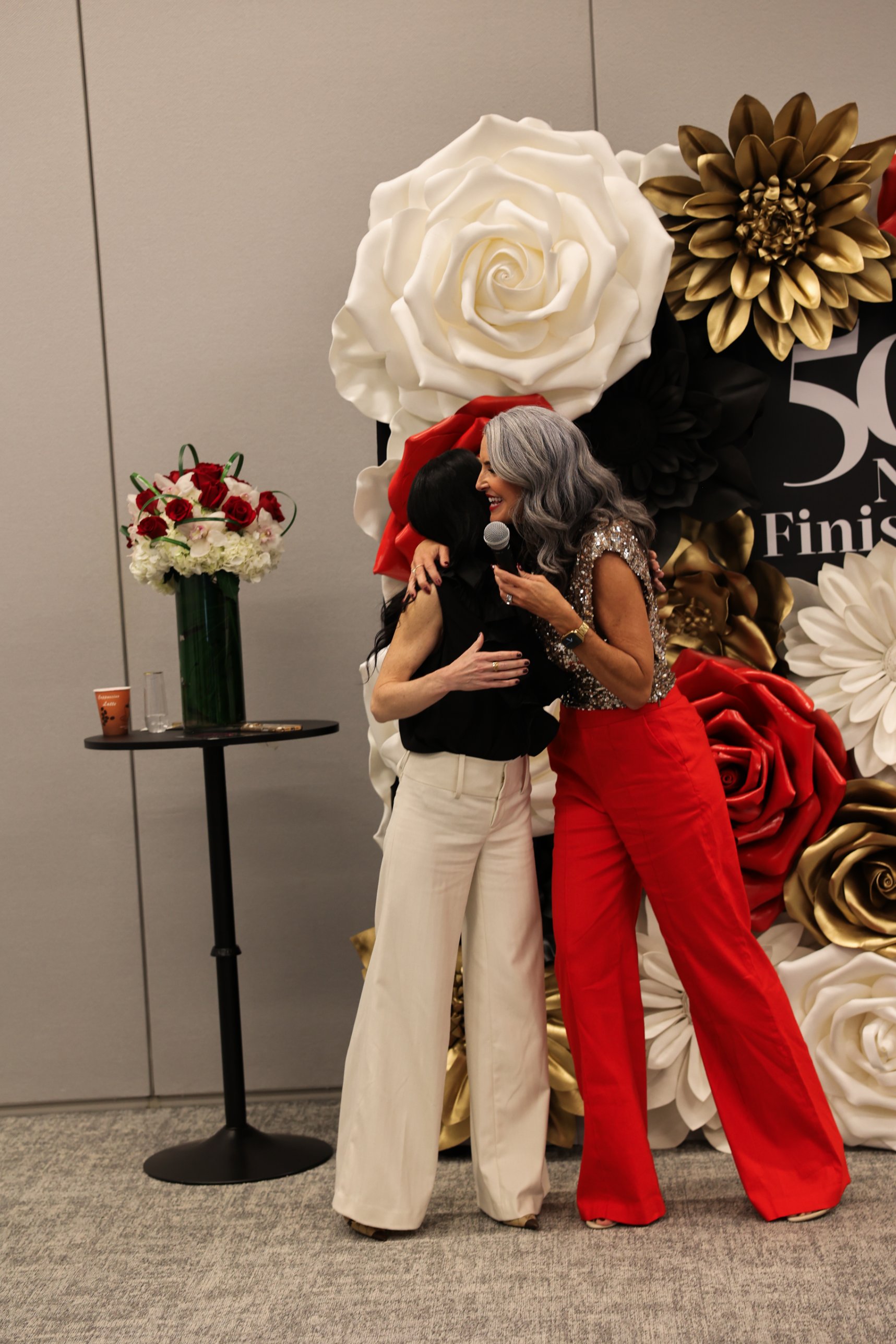 Julie Ciardi and Sara Connell hugging at the 50 Not Finished event