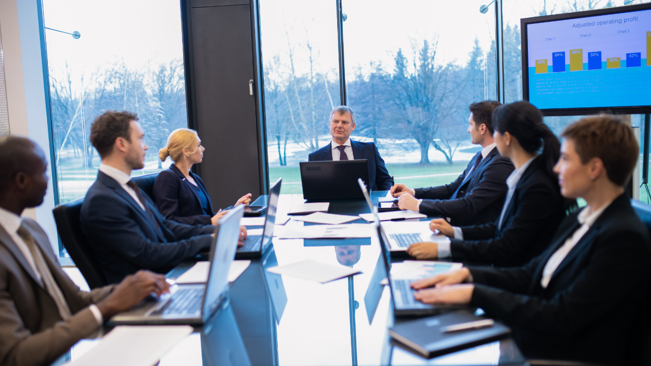 An experienced executive coach leading a corporate leadership training session in a modern Tampa boardroom.