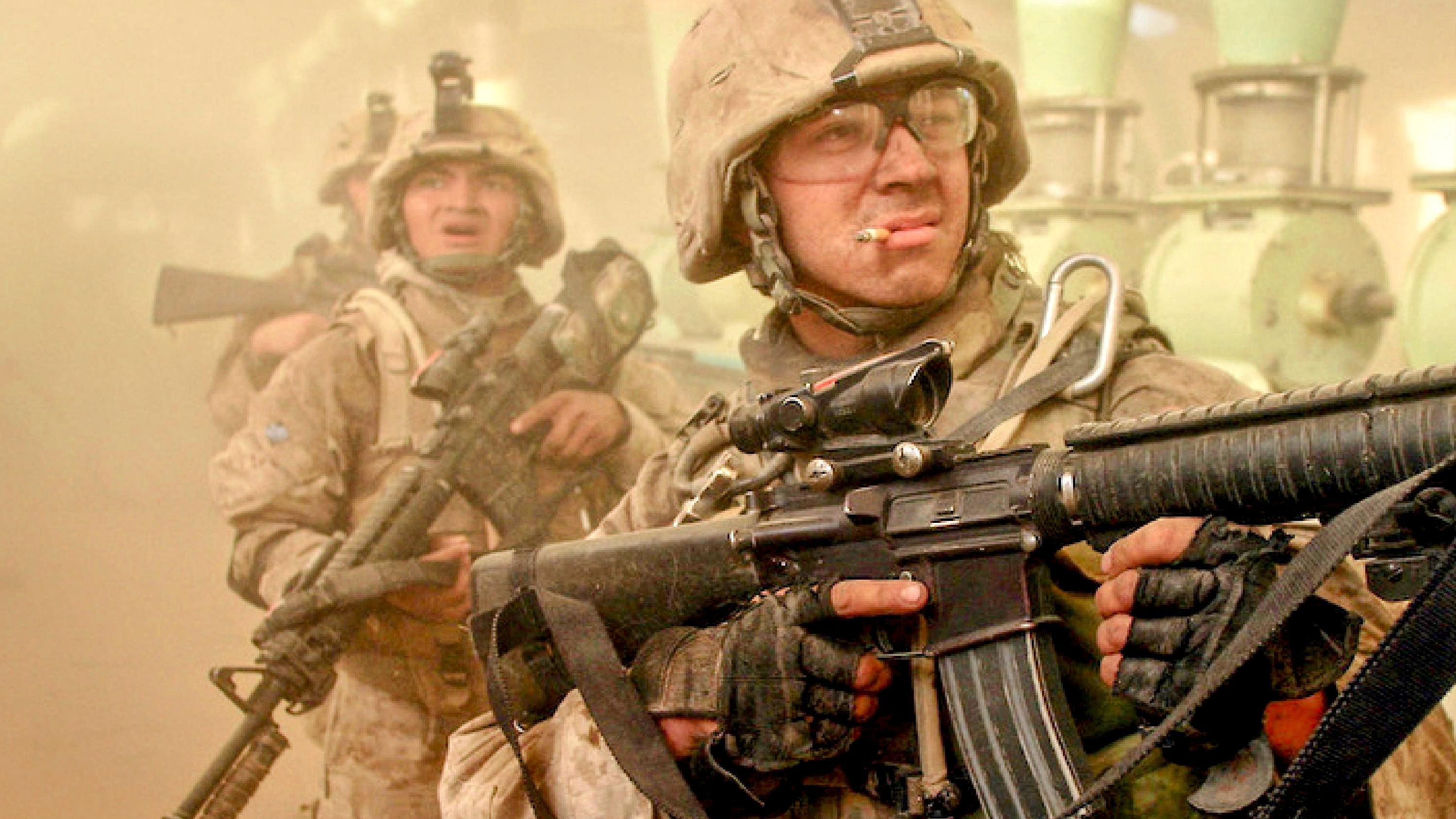 U.S. Marines in combat gear advancing through a dusty battlefield, symbolizing leadership, teamwork, and front-line mission focus.