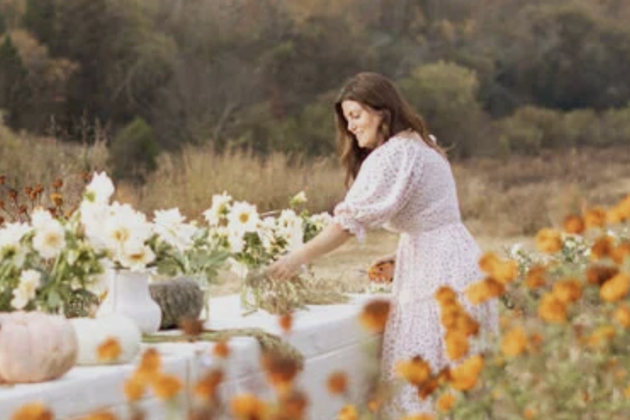 Carolyn Hunter arranging flowers on an outdoor table at The Tennessee Peony Farm