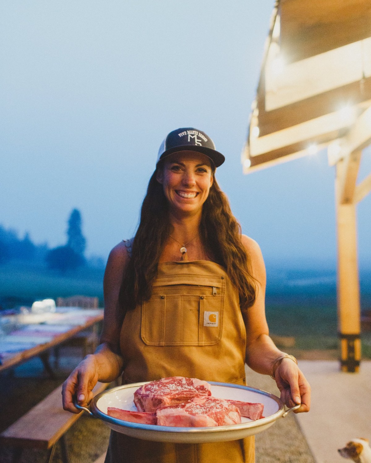 Holding a platter of salted Five Marys steaks outside at dusk