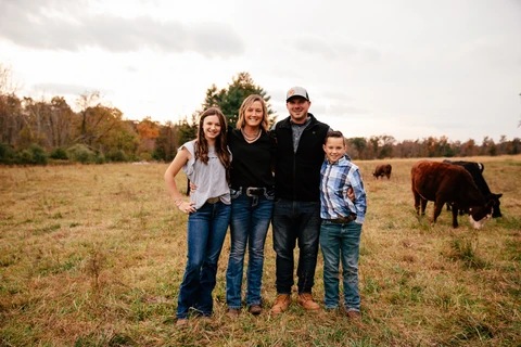 Elise Haring and her family in a pasture with their cattle at Haring Family Farm
