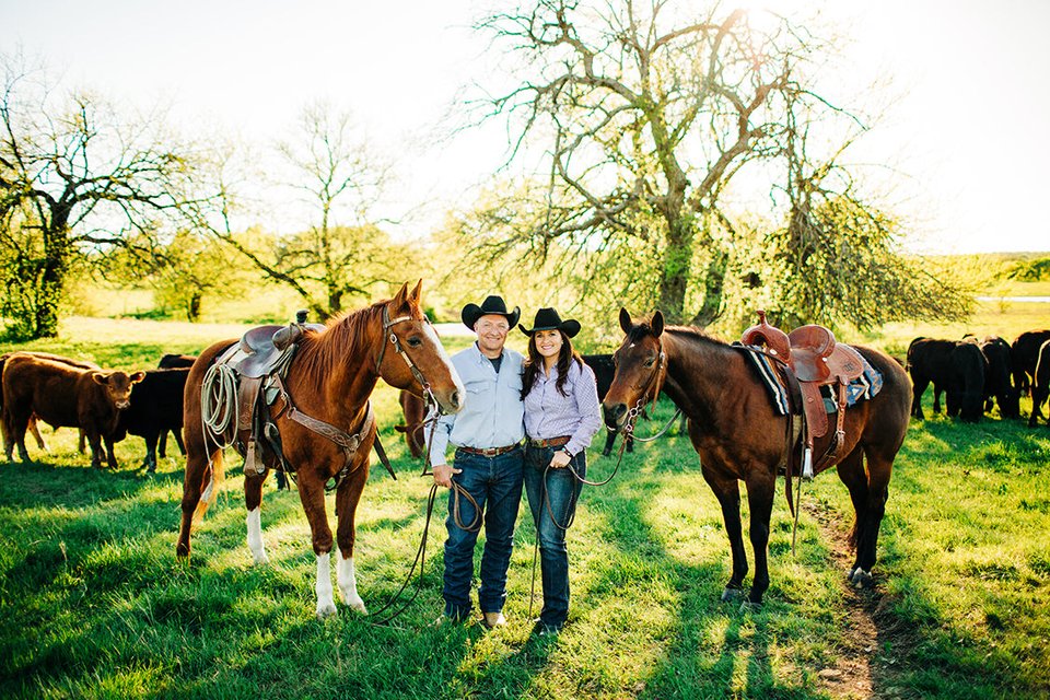 Nikki and Roger Callison standing with their horses and cattle