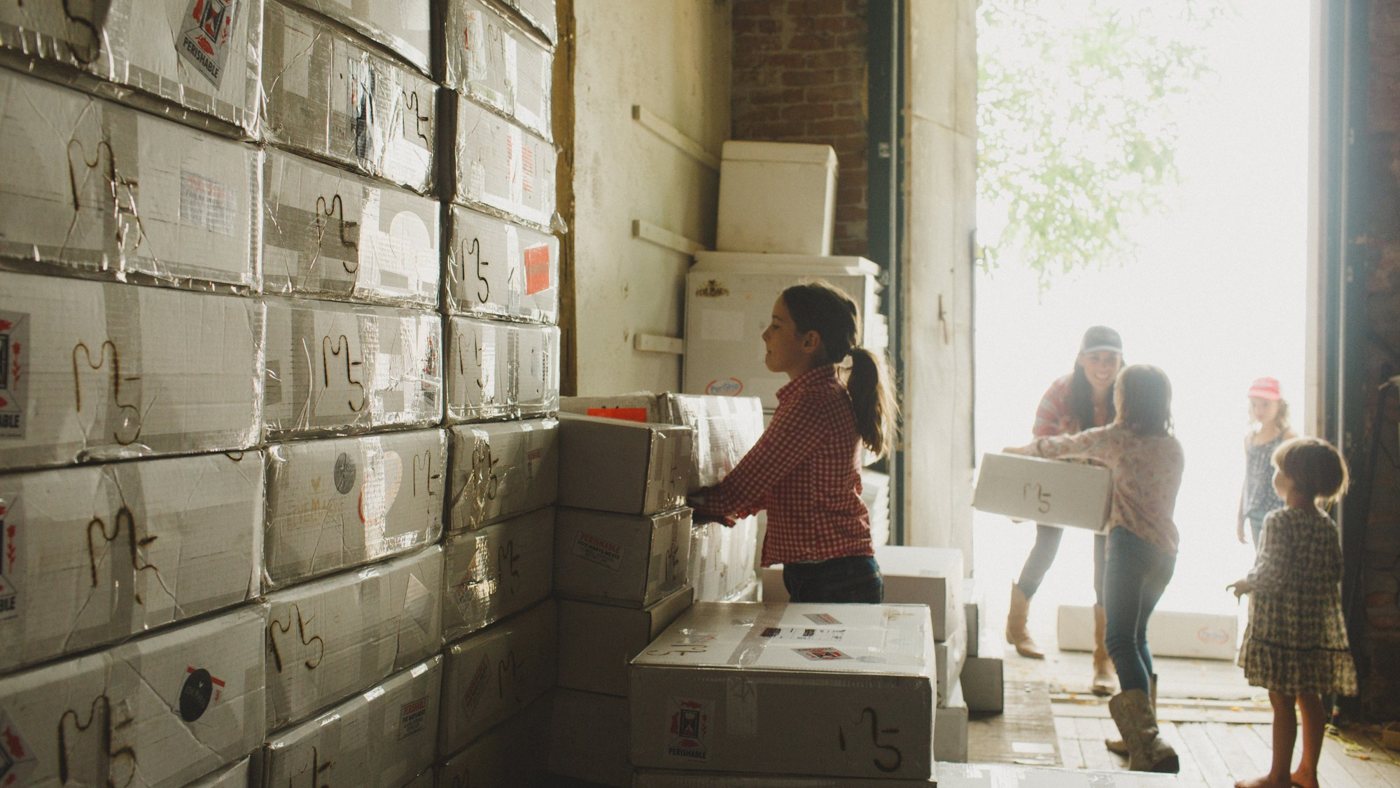 The Heffernan girls carrying Five Marys boxes out of the shipping room