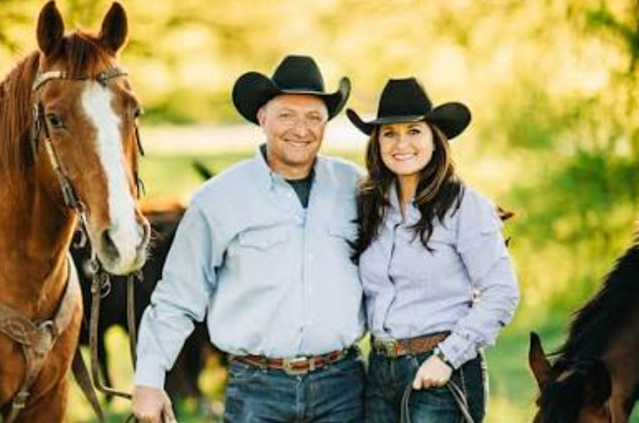 Nikki and Roger Callison standing with their horses and cattle