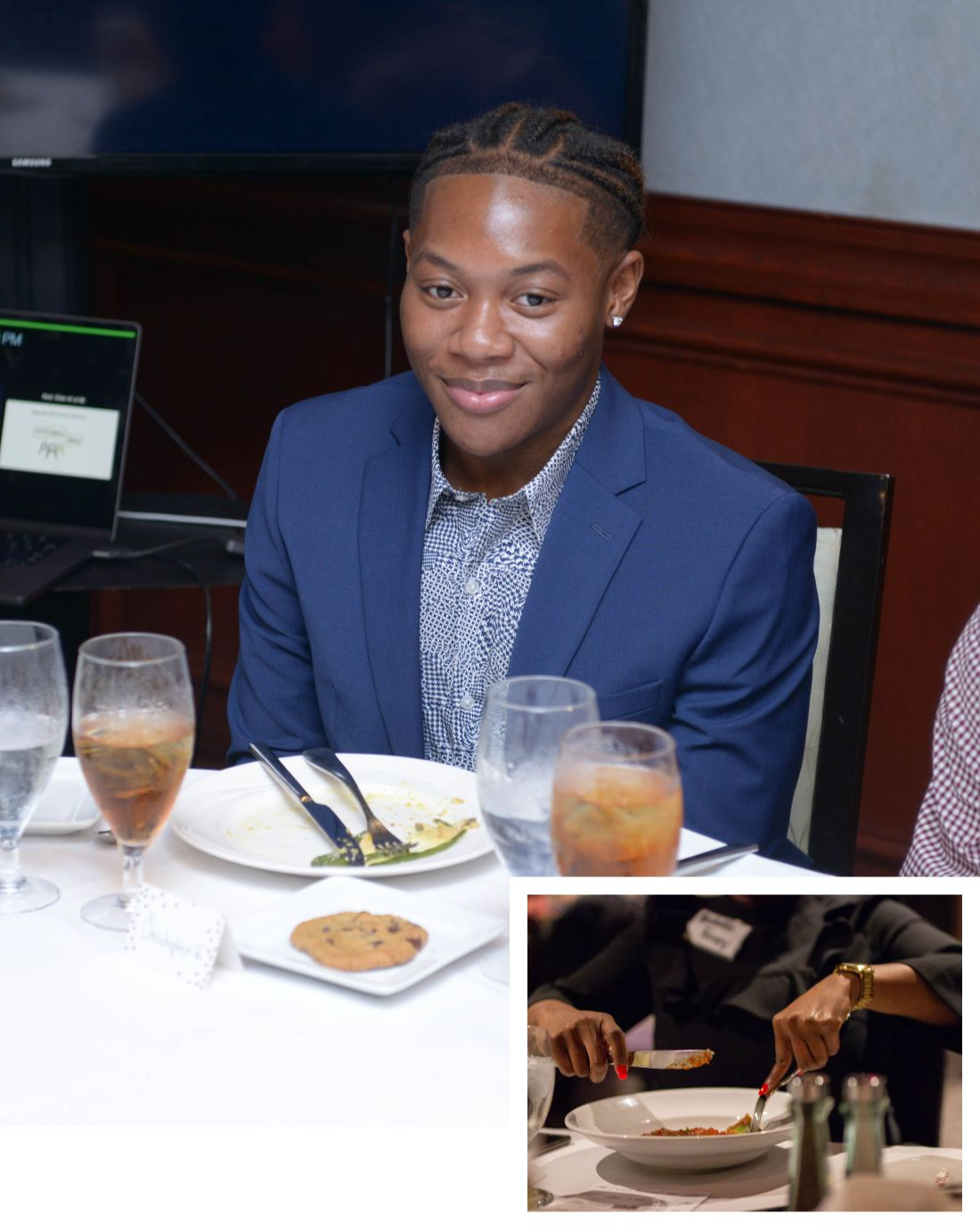 Two young men smiling at a formal dinner table