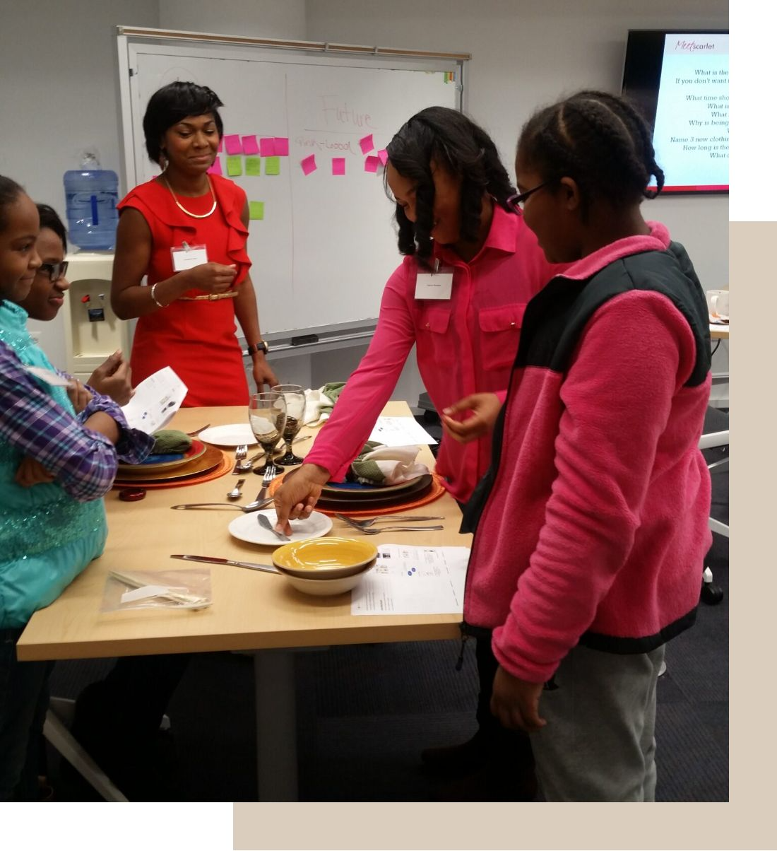 Women and girls learning to set a formal table together