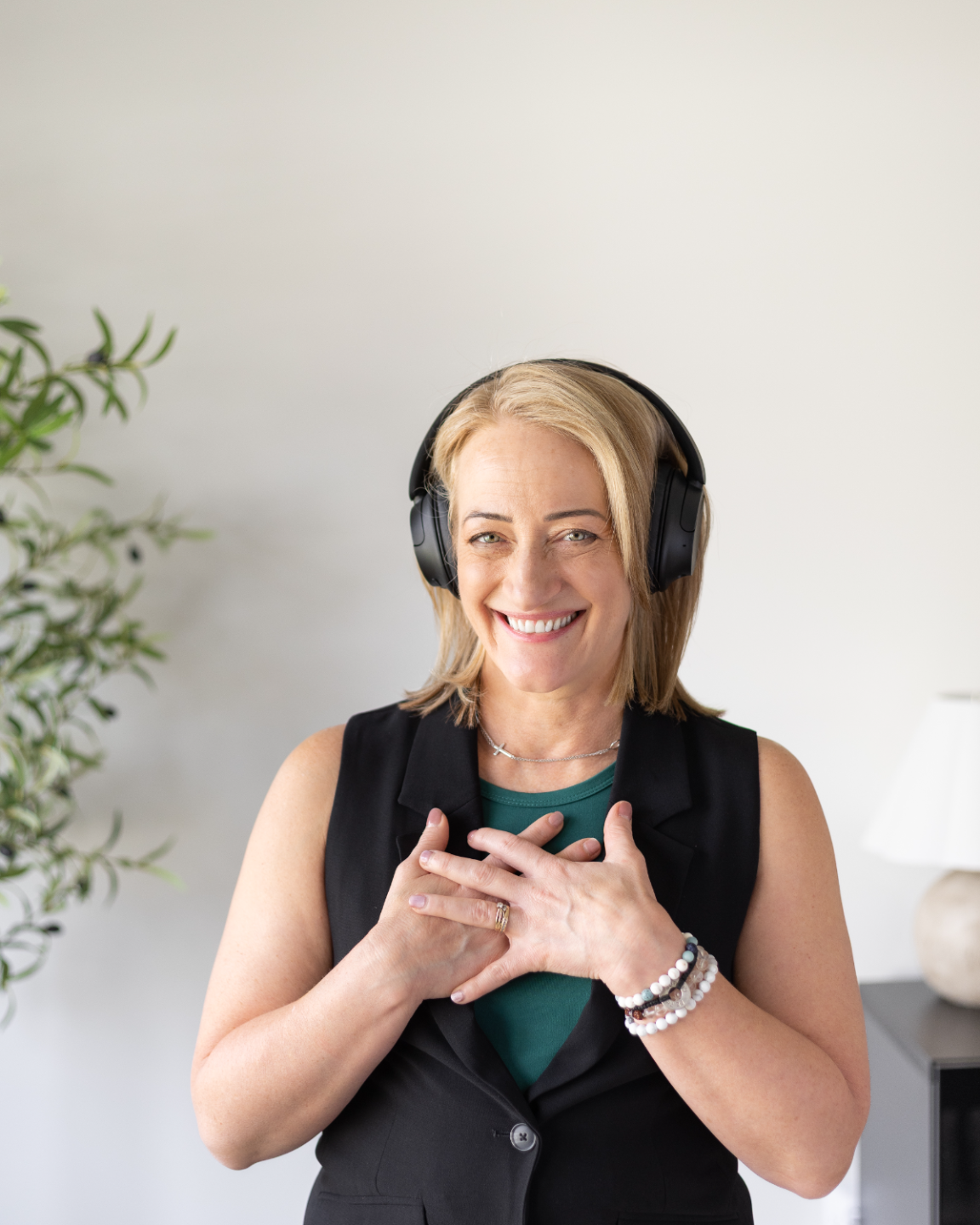 Marsha smiling in headphones with her hands resting on her heart