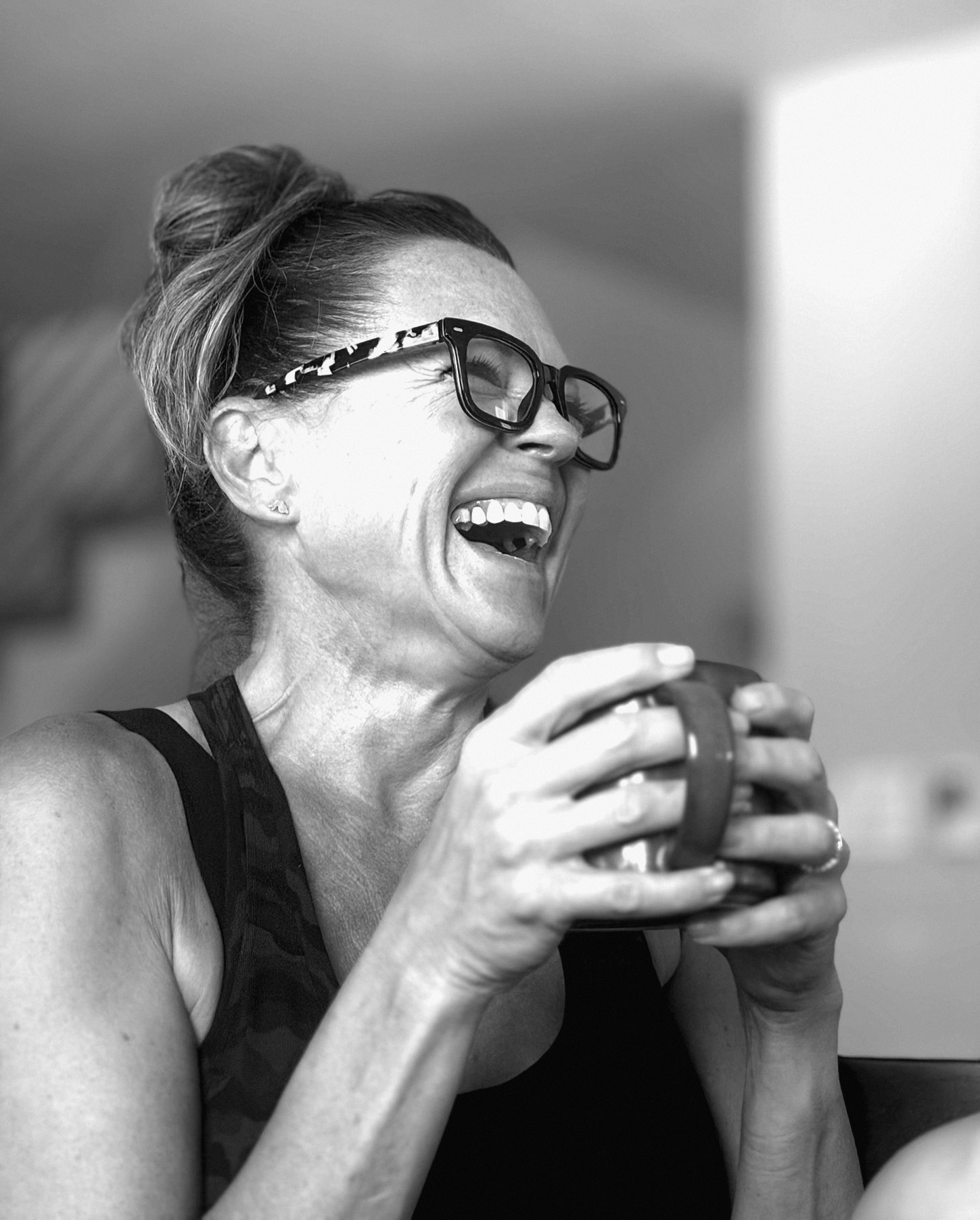 Alicia laughing with a mug of coffee