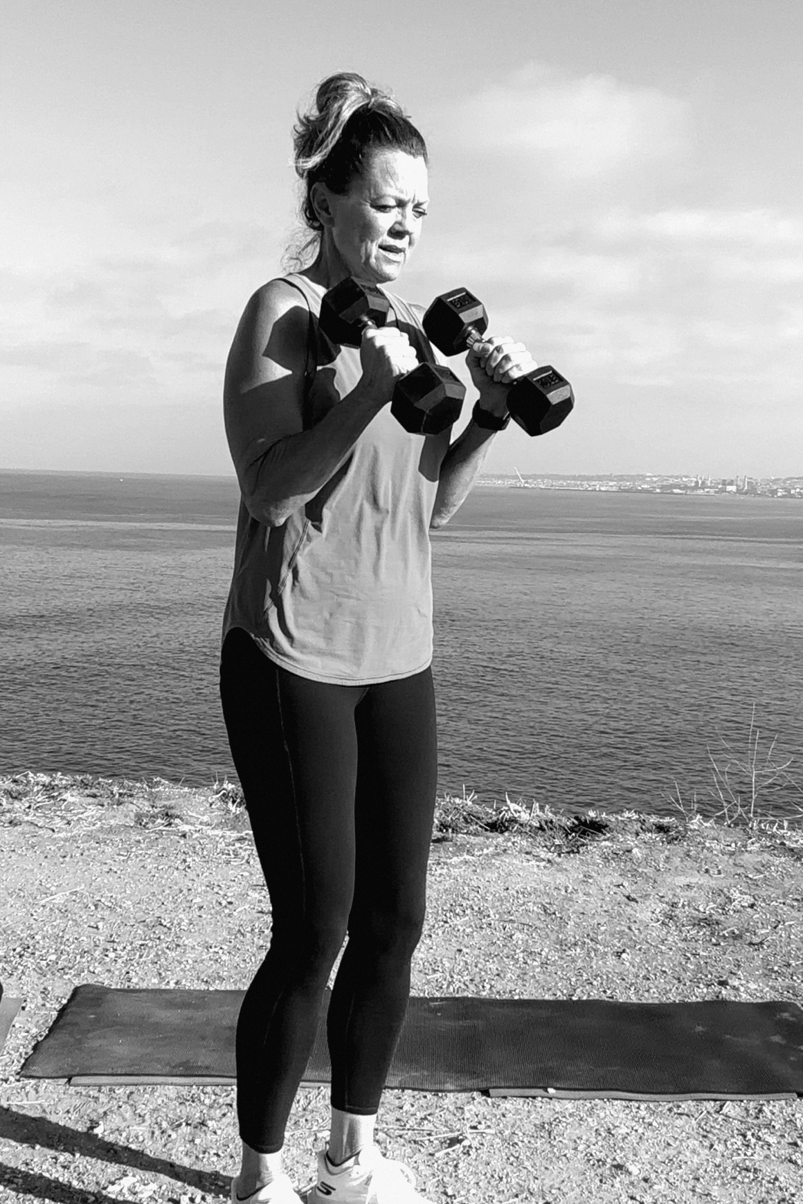Alicia doing dumbbell curls on the cliffs