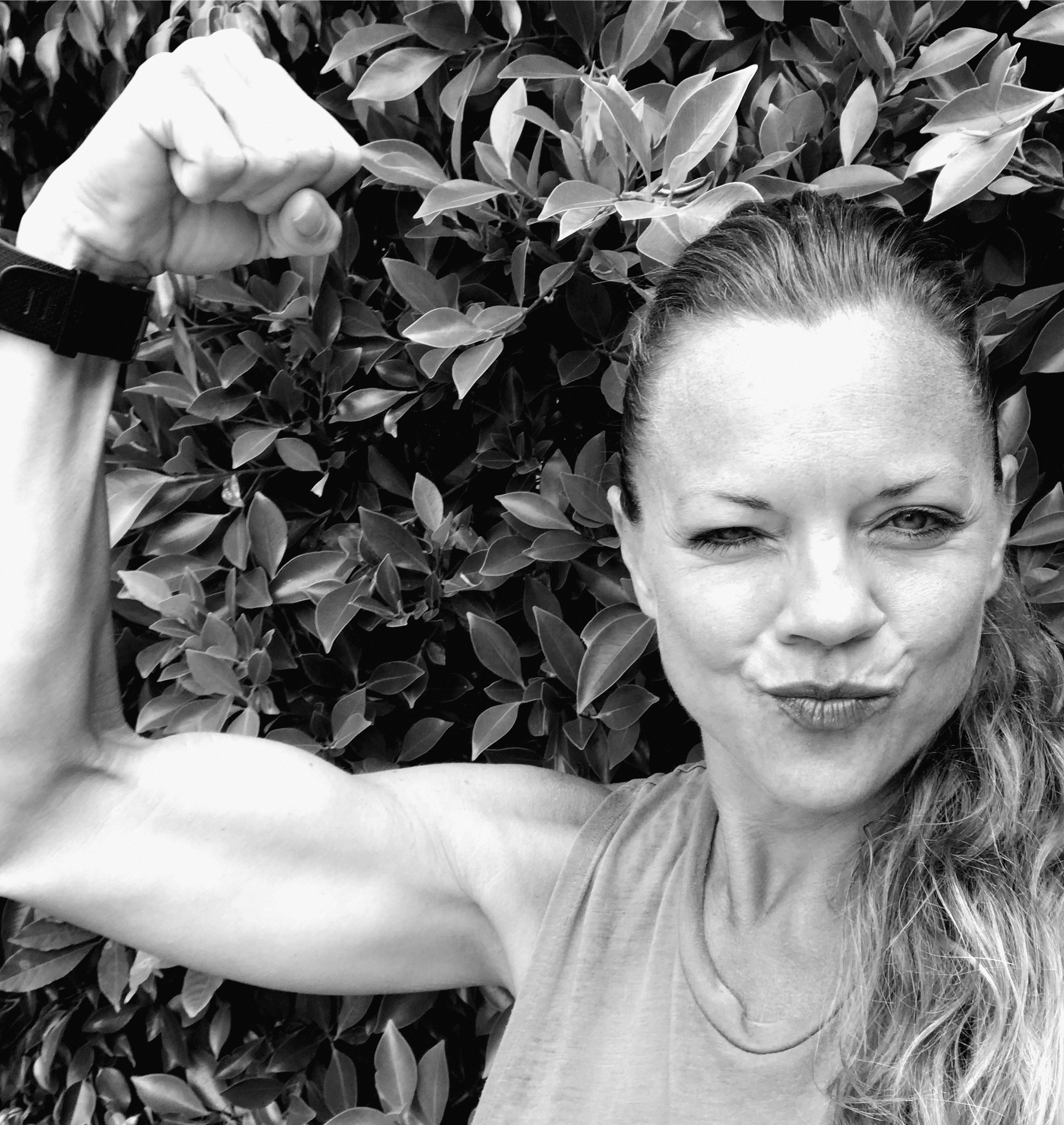 Alicia flexing her bicep and making a kissy face