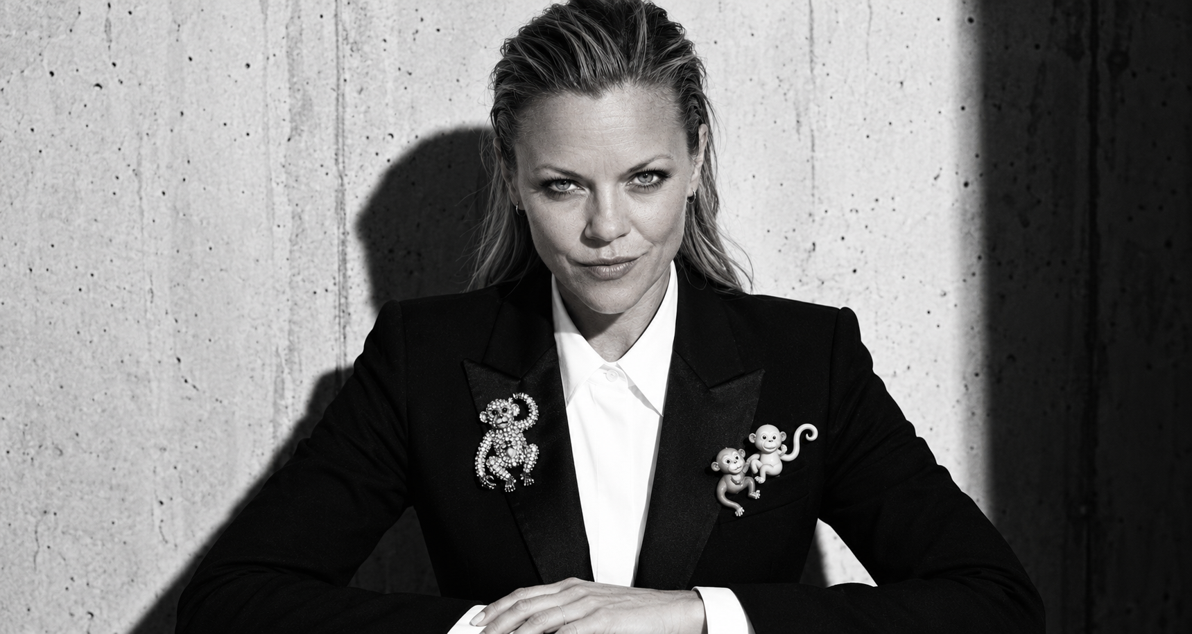 Coach Alicia in a black blazer with monkey brooches
