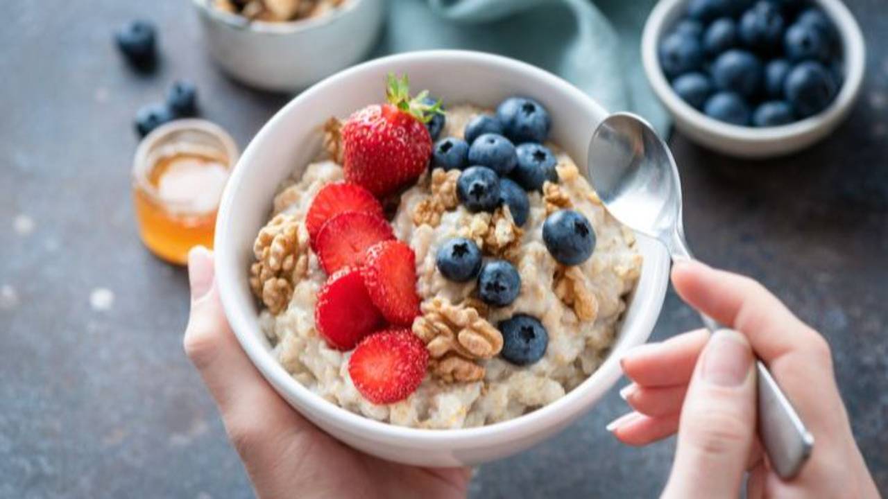 bowl of oats topped with blueberries, strawberries and walnuts