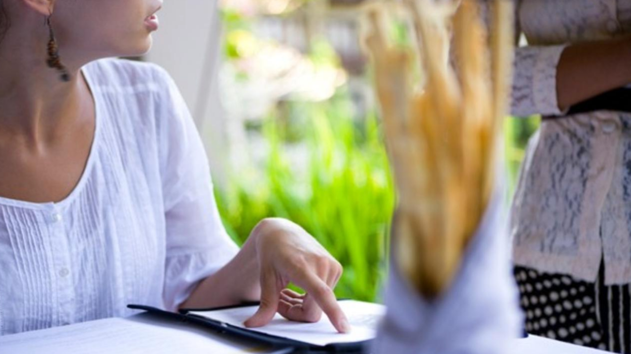 woman pointing to restaurant menu